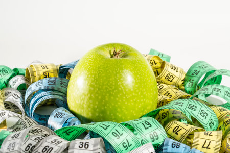 Green apple and measuring tape isolated on white background. Diet and weight loss conceptの写真素材