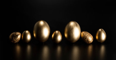 Easter, Gold birds eggs shot against a dark backgroundの写真素材