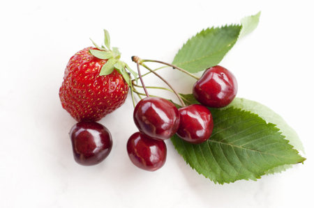 Healthy Organic Strawberry and Cherries on a White Tableの写真素材