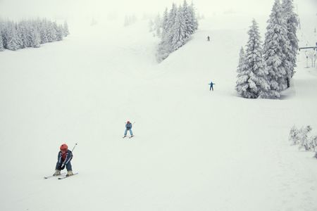 Young skiers on the slope in the light fogの写真素材