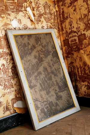 Beautiful wooden frame mirror in old building without people. Old building consisting of frame...