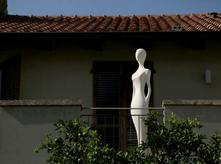 Photography to theme beautiful white naked mannequin, dummy female on house background. Photo consisting of naked mannequin outdoors, female dummy side view. Naked mannequin from plastic female dummy.の写真素材