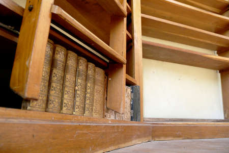 Personal library consisting of big empty bookcase with wooden bookshelf for books. Bookshelf to books of empty library from bookcase. Old bookcase with empty bookshelf for books in abandoned library.の写真素材