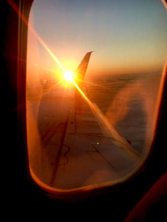Beautiful view from airplane window, large wing of aircraft shows casement. Windows aircraft show long wing airplane. Airplane with wings, windows is fly aircraft for flying in blue sky on thick fog.の写真素材