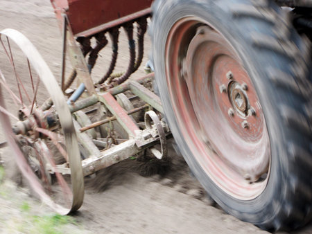 Plowed field by tractor in brown soil on open countryside nature. Tractor in plowed field, soil to...