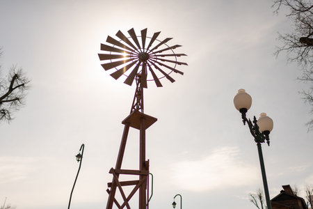 Photography to theme old wind turbine with blades on cloudy sky background, photo consisting of old...