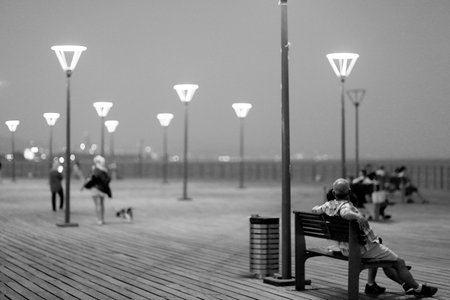 Night led street lights with energy saving lamps for fashion beauty, metal led street lights consists of bright glass lamps, steel led street lights illuminating road for people white lamps near oceanの写真素材
