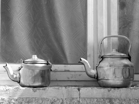 Copper teapots standing to concrete sill, kettles on street shop window before glass, teapot consisting of copper kettles with handle, spout for draining liquid coffee, copper kettles is iron teapotsの写真素材