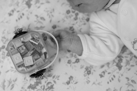 Beautiful baby boy with child toy posing photographer for color photo, cadre consisting of baby boy holding child homemade toy in his hand, healthy baby boy on child toy lying relaxing for good shotの写真素材