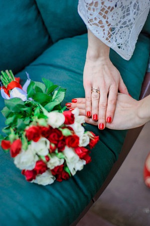 Wedding Bridal bouquet with white and red roses in her hands on blue backgroundの写真素材