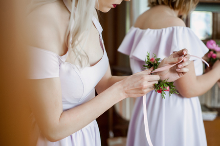 Bridesmaid preparing bride for the wedding day.の写真素材
