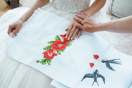 mother preparing bride for the wedding day and helps before the ceremony.の写真素材