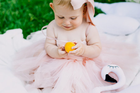 infancy and age concept . beautiful happy baby in pink dress in the park playingの写真素材