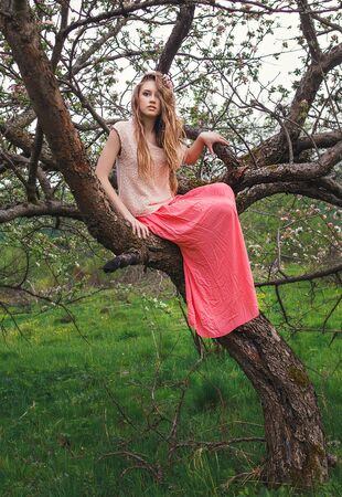 Beautiful girl in the spring garden with flowersの写真素材