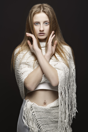 Beautiful blond woman with long straight hair and style makeup. Model posing on dark background.の写真素材
