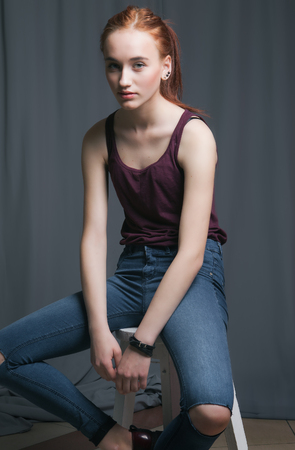 Beautiful woman with long red color straight hair and style makeup. Model posing on grey background.の写真素材