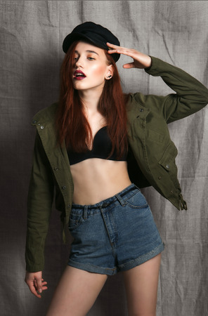 Beautiful woman with long red color straight hair and style makeup. Model posing on grey background.の写真素材