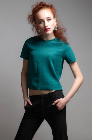 Beautiful woman with long red color straight hair and style makeup. Model posing on grey background.の写真素材