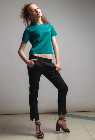 Beautiful woman with long red color straight hair and style makeup. Model posing on grey background.の写真素材