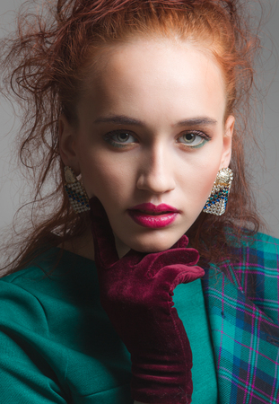 Beautiful woman with long red color straight hair and style makeup. Model posing on grey background.の写真素材