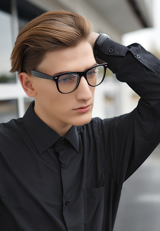 Studio fashion portrait of an elegant young handsome man outdoor.の写真素材