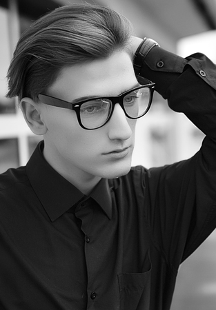 Studio fashion portrait of an elegant young handsome man outdoor.の写真素材