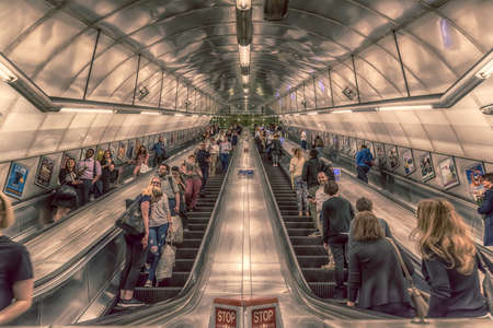 Looking up at symmetrical stainless steel escalators leading out from London Underground tube station.のeditorial素材