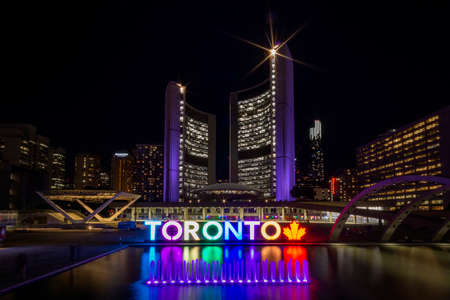 Colourful and illuminated Toronto sign at Nathan Phillips square during the evening in Toronto, Canada. The Square is used regularly for art exhibits and concertsのeditorial素材