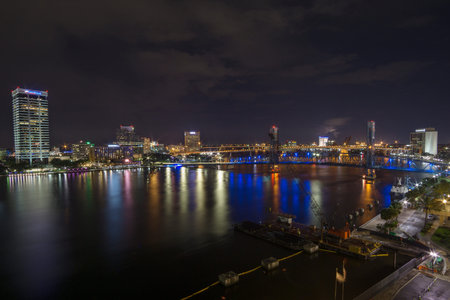night scene of downtown Jacksonville Florida Landing area beside the St. Johns river showing the Main Street Bridge and large well lit buildings.のeditorial素材