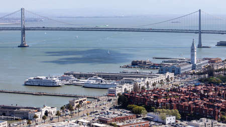 Aerial cityscape of San Francisco Embarcadero and Oakland Bridge from top of Coit Tower on sunny day on Telegraph Hill, California, United States.のeditorial素材