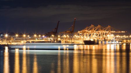 Cranes at Port of Seattle terminal at night, Washington, USA