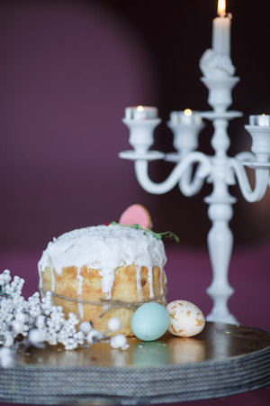 Easter table with colorful eggs and spring flowers on blurred kitchen window background. High...