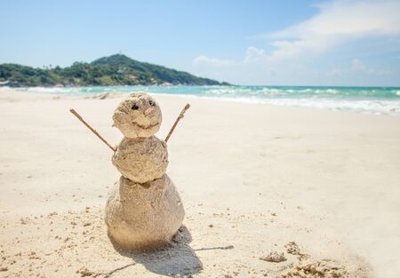 snowman made of sand on a background of the tropical warm seaの写真素材