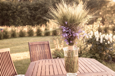 A bouqet of wildflowers on a wooden table in gardenの写真素材