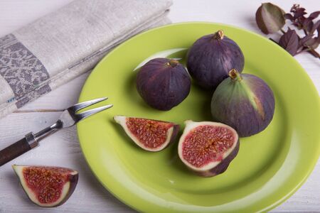 Serving the table, fresh figs, fruits, berries, cheese, nuts on a white wooden backgroundの写真素材