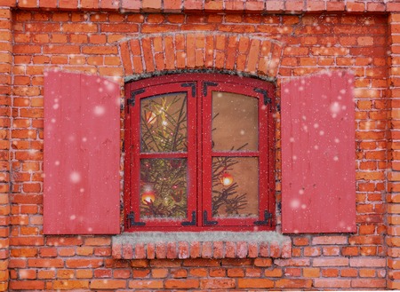 Red window on the facade of the old brick house.Christmas background, winter window, Christmas decoration.の写真素材