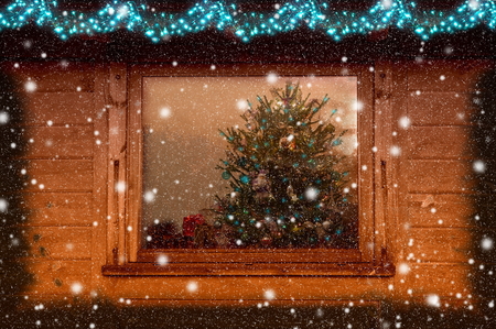 Christmas tree through the evening window. Winter background. Christmas background. Christmas windowの写真素材