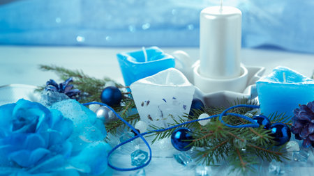 Christmas composition. Pine cones, spruce branches, handmade candles, Christmas blue decor on a wooden white backgroundの写真素材