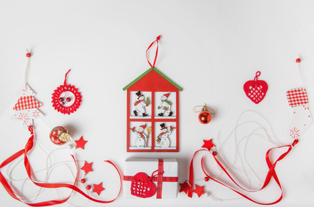 Christmas holiday composition. Festive creative red pattern, xmas decor holiday ball with ribbon, snowflakes, christmas tree, socks on white background.の写真素材
