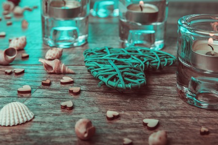 Spa concept in Valentine's Day, candles, handmade heart, seashells, dry roses. Rustic style. Toned image in chocolate, aquamarine tones. Healthy Conceptの写真素材
