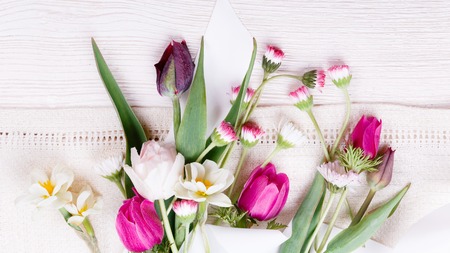 Bouquet first spring flowers, pink, purple tulips, daffodils and daisies on white wooden background. Overhead top view, flat lay. Easter, Birthday, Mother's, Valentines, Women's, Wedding Day concept.の写真素材
