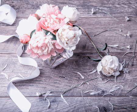 Delicate white pink peony with petals flowers and white ribbon on wooden board. Overhead top view, flat lay. Copy space. Birthday, Mothers, Valentines, Womens, Wedding Day conceptの写真素材