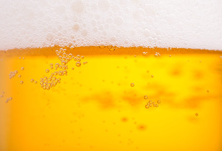 Pouring beer with bubble froth in glass for background