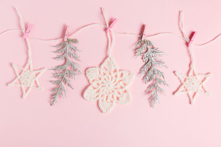 Christmas composition of crocheted white snowflakes and stars on pink background. Top view, flat lay, copy space.の写真素材