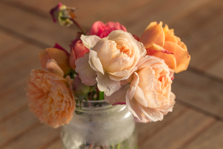 Bouquet of English roses with hoarfrost on the petals on the old wooden table, rustic style.の写真素材
