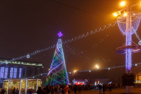 Minsk, Belarus - December 30, 2018: Christmas tree, illuminations and decorations in front of building of the Palace of Republic in Oktyabrskaya Square.のeditorial素材