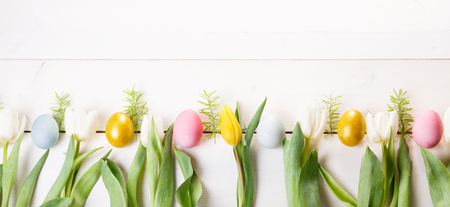 Easter background with Easter eggs and spring flowers. Top view with copy spaceの写真素材