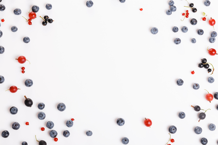 Fresh blueberries, red and black currants, gooseberries, summer berry ornament on a white backgroundの写真素材