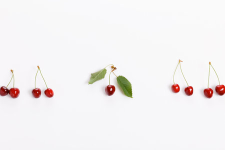 Tropical summer abstract background. Cherry cherries with cuttings and leaves on the white background.の写真素材