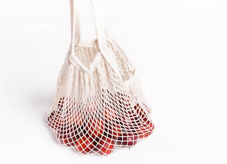 Organic apples in wicker bag for shopping on white background, eco shopping bag concept.の写真素材